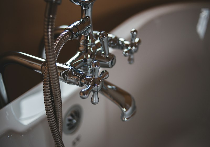Plumber working on pipes under a kitchen sink